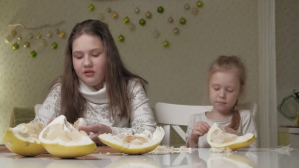 Две сестры едят фрукты Помело — стоковое видео