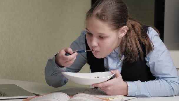 Дівчина-підліток у шкільній формі робить домашнє завдання — стокове відео