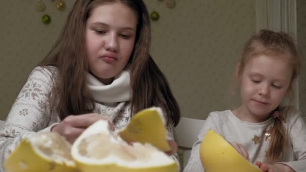 Two sisters eating pomelo fruit — Stock Video