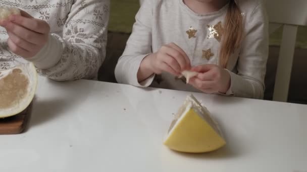 Two sisters eating pomelo fruit — Stock Video