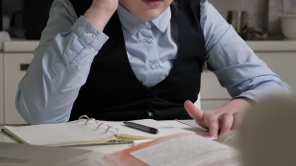 Adolescente en un uniforme escolar hace la tarea — Vídeo de stock