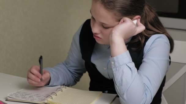 Teenagermädchen in Schuluniform macht Hausaufgaben — Stockvideo