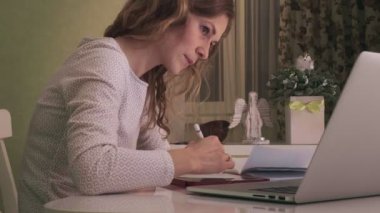 Genç bir kadın evdeki bilgisayar tabletinde çalışıyor..