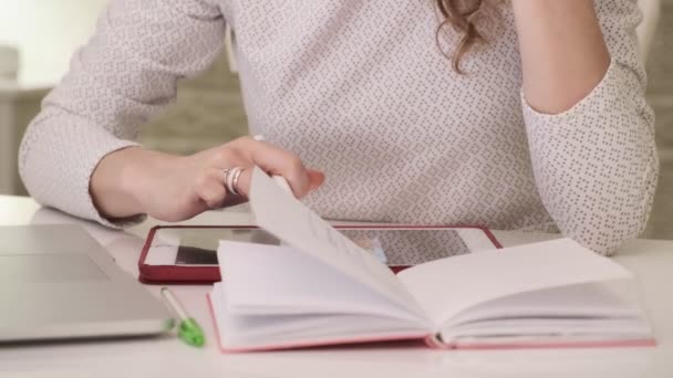 Een jonge vrouw werkt thuis op een computer tablet. — Stockvideo