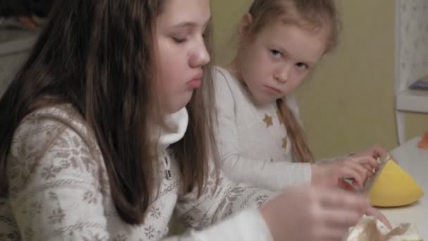 Två systrar äter pomelo frukt — Stockvideo