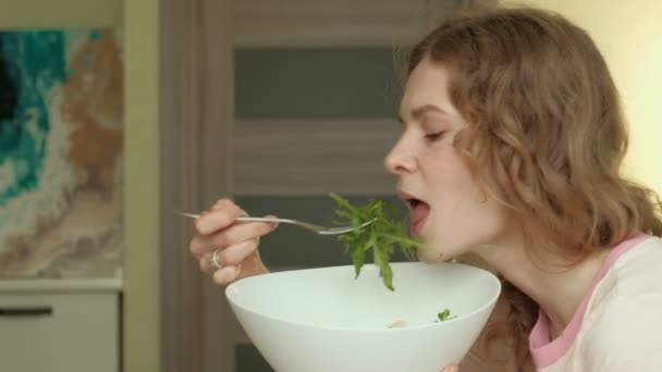 Young woman eats greens salad. — Stock Video