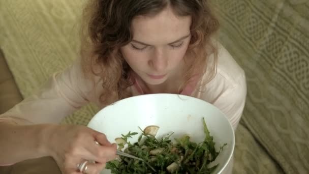 Молода жінка їсть зелений салат . — стокове відео