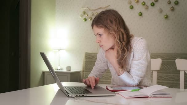 A young woman works at a computer at home. — Stock Video