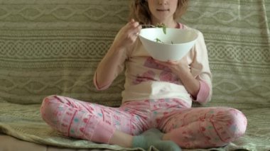 Genç kadın yeşil salata yiyor..