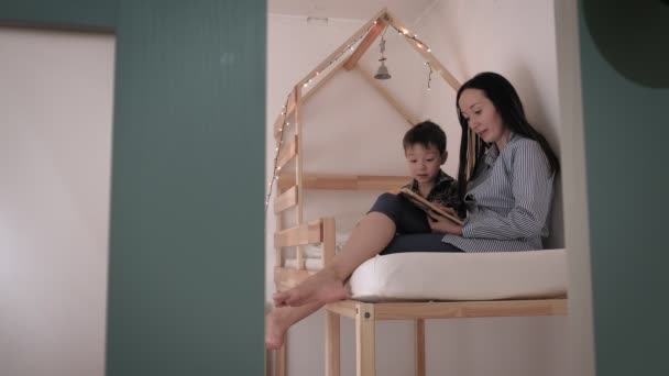 Mutter liest ihrem Kind vor dem Schlafengehen ein Buch vor. Schlaflosigkeit, böser Traum — Stockvideo