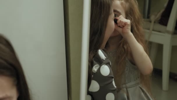 Fröhliches Kind mit Schwester in Kleidern schminken sich gegenseitig. — Stockvideo