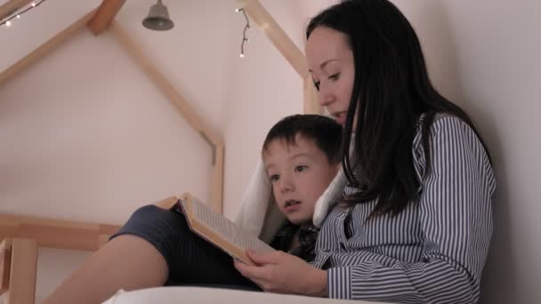 Mutter liest ihrem Kind vor dem Schlafengehen ein Buch vor. Schlaflosigkeit, böser Traum — Stockvideo