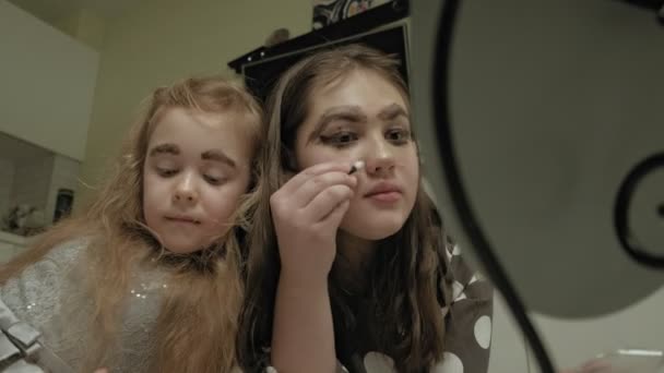 Glada barn med syster i klänningar gör varandra make-up. — Stockvideo