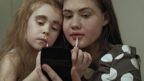 Alegre niño con hermana en vestidos hacen uno al otro maquillaje . — Vídeo de stock