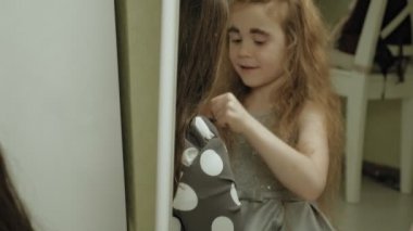 Elbiseli kız kardeşi olan neşeli bir çocuk birbirlerine makyaj yapar..