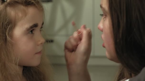 Vrolijk kind met zus in jurken maken elkaar make-up. — Stockvideo