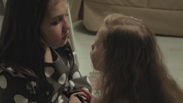 Alegre niño con hermana en vestidos hacen uno al otro maquillaje . — Vídeo de stock