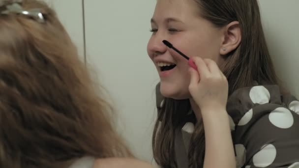ドレスの妹と陽気な子供はお互いの化粧を作る. — ストック動画