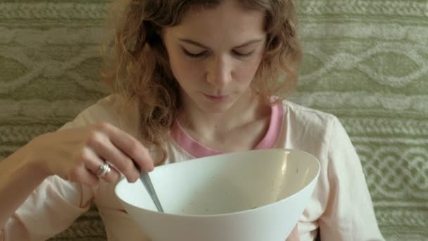 Молодая женщина ест зеленый салат . — стоковое видео