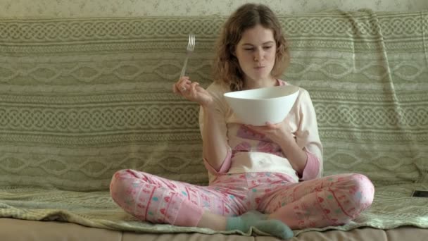 Νεαρή γυναίκα τρώει πράσινη σαλάτα. — Αρχείο Βίντεο