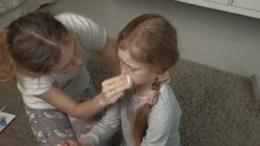 Annesi, burnu kanayan bir çocuğa ilk yardım sağlıyor..