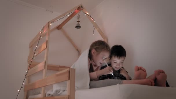 Kinder benutzen Tablet im Bett — Stockvideo