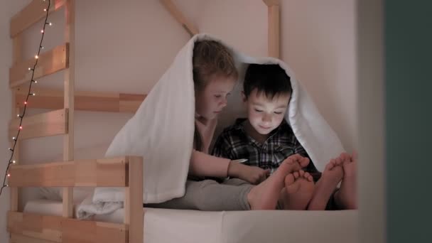 Les enfants utilisent un comprimé pendant qu'ils sont couchés au lit — Video