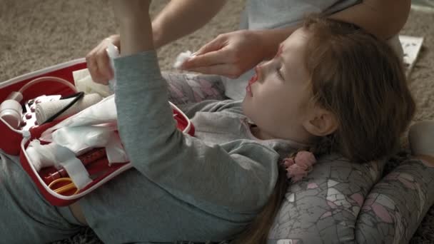 Η μαμά παρέχει πρώτες βοήθειες σε ένα παιδί με ματωμένη μύτη.. — Αρχείο Βίντεο