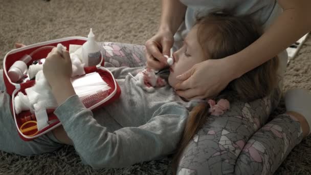 Mamá proporciona primeros auxilios a un niño con la nariz ensangrentada . — Vídeos de Stock