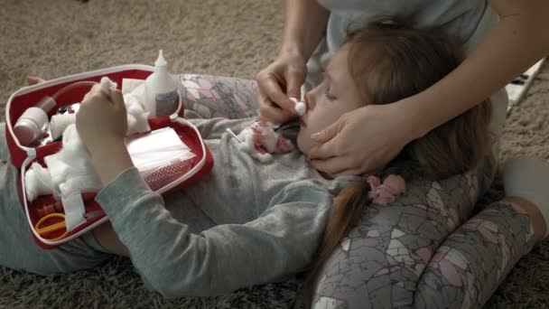 Mamma ger första hjälpen till ett barn med blodig näsa. — Stockvideo