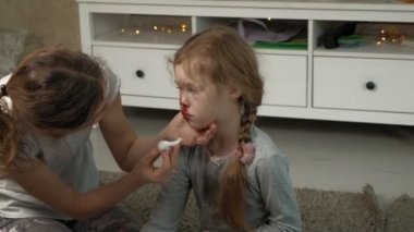 Annesi, burnu kanayan bir çocuğa ilk yardım sağlıyor..