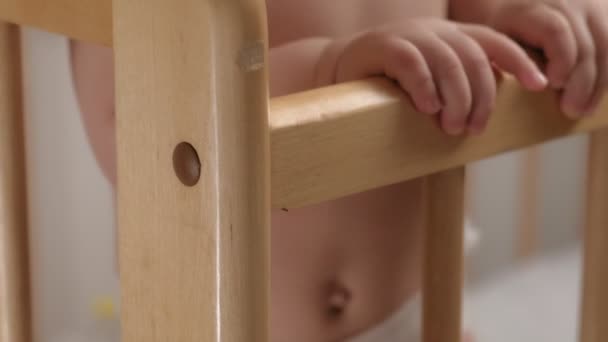 Baby handgrepen peuter vasthouden aan de wieg. — Stockvideo