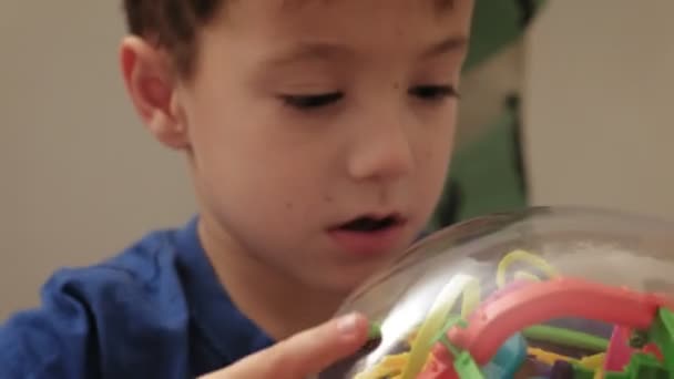 Niño preescolar juega con rompecabezas juego — Vídeo de stock