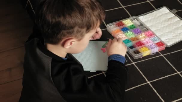 Niño juega con perler perlas. desarrollo motor fino — Vídeos de Stock