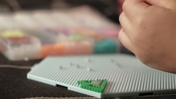 Niño juega con perler perlas. desarrollo motor fino — Vídeo de stock