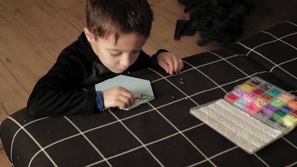 Niño juega con perler perlas. desarrollo motor fino — Vídeo de stock