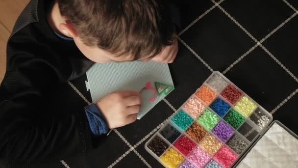 Child plays with perler beads. fine motor development — Stock Video