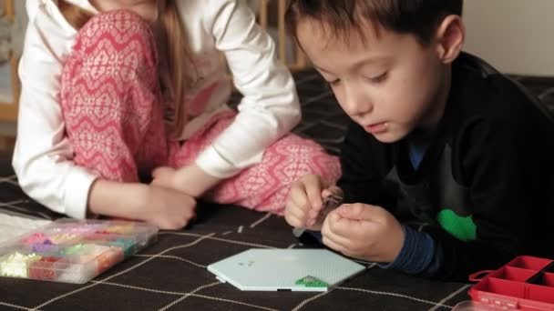 Child plays with perler beads. fine motor development — Stock Video