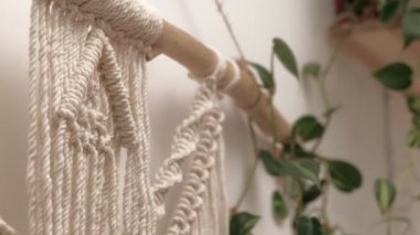 Kadın çubuğa makrome örüyor..