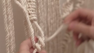 Kadın çubuğa makrome örüyor..