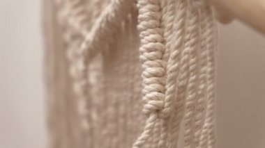 Kadın çubuğa makrome örüyor..