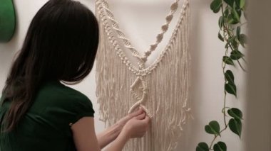 Kadın çubuğa makrome örüyor..