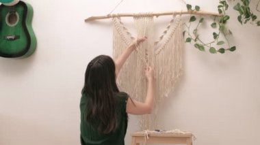 Kadın çubuğa makrome örüyor..