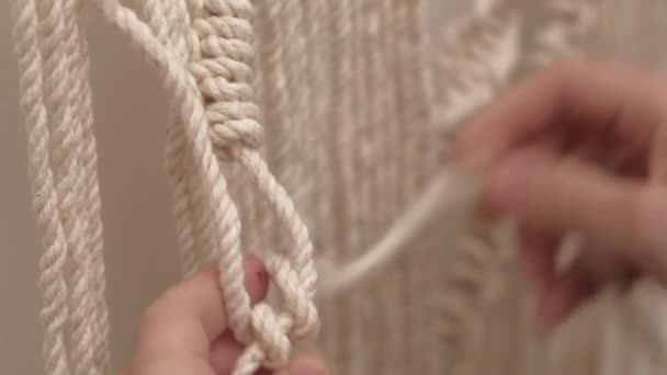 Vrouw weeft macrame op een stok. — Stockvideo