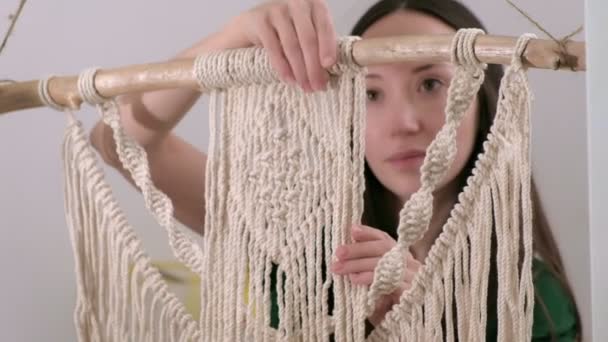 Vrouw weeft macrame op een stok. — Stockvideo