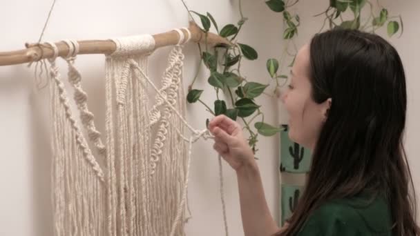 Woman weaves macrame on a stick. — Stock Video