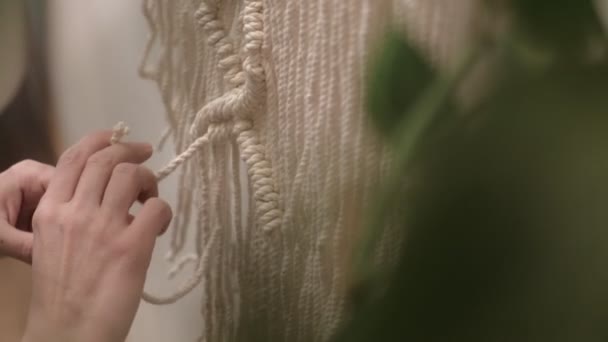 Woman weaves macrame on a stick. — Stock Video