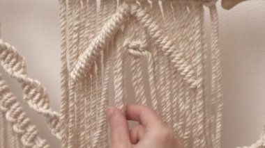 Kadın çubuğa makrome örüyor..