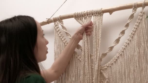 Woman weaves macrame on a stick. — Stock Video