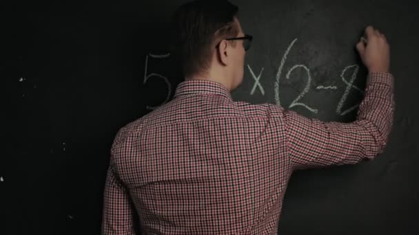 Hombre escribe fórmula matemática en pizarra — Vídeo de stock